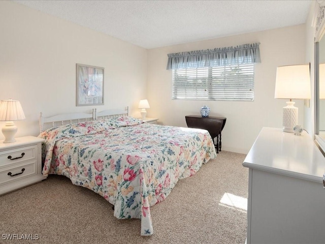 bedroom with light colored carpet and a textured ceiling