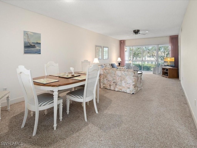 carpeted dining area with ceiling fan