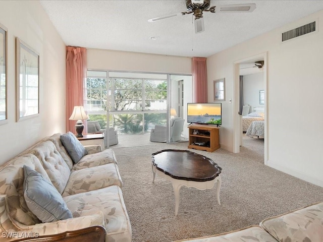 living room with light carpet, a textured ceiling, and ceiling fan