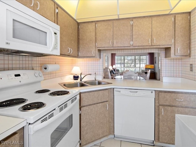 kitchen with light tile patterned flooring, white appliances, sink, and tasteful backsplash