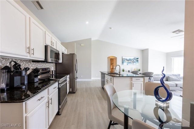 kitchen with backsplash, sink, appliances with stainless steel finishes, light hardwood / wood-style floors, and white cabinetry