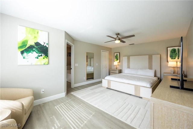 bedroom featuring light wood-type flooring, a closet, and ceiling fan