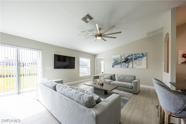 living room with light hardwood / wood-style floors, ceiling fan, and lofted ceiling