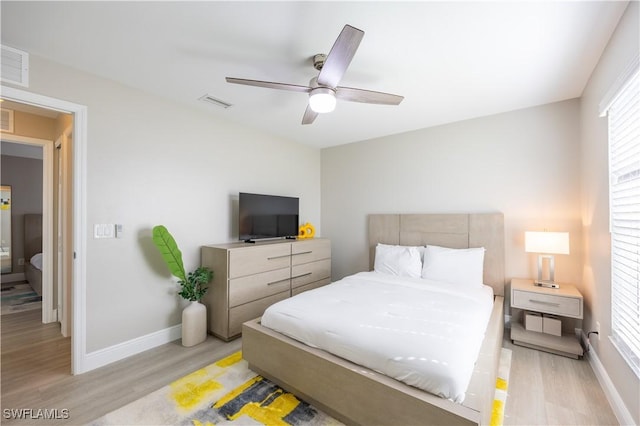 bedroom with multiple windows, light hardwood / wood-style floors, and ceiling fan