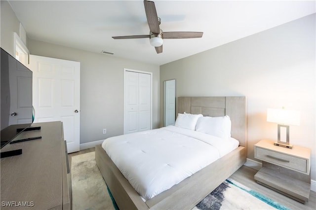 bedroom featuring ceiling fan, a closet, and light hardwood / wood-style floors