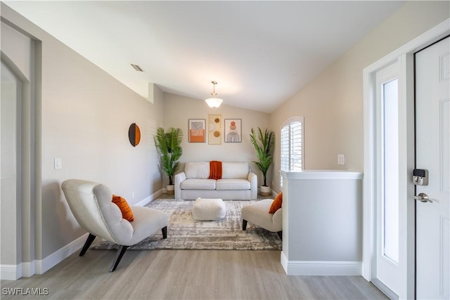 living room featuring light wood-type flooring and vaulted ceiling