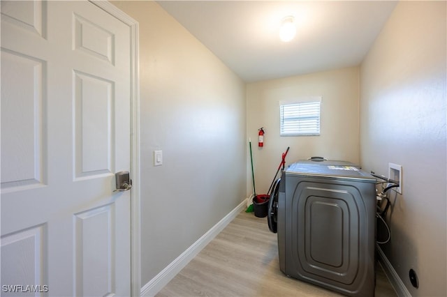 clothes washing area featuring light hardwood / wood-style floors and washer / dryer