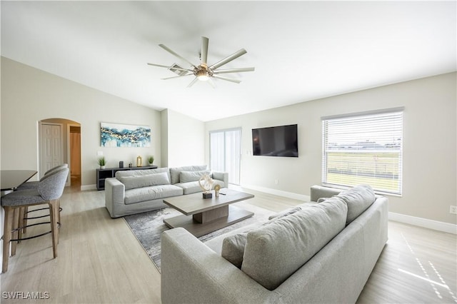 living room featuring ceiling fan, light wood-type flooring, and vaulted ceiling