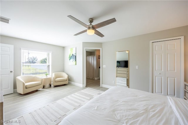 bedroom featuring ceiling fan, light hardwood / wood-style floors, and a closet