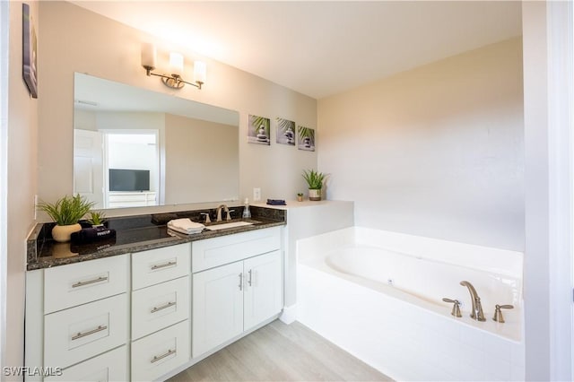 bathroom with vanity and a bath