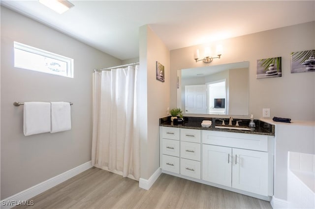 bathroom featuring hardwood / wood-style floors, vanity, and walk in shower