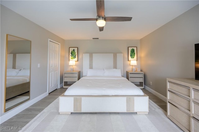 bedroom with ceiling fan, a closet, and light hardwood / wood-style floors