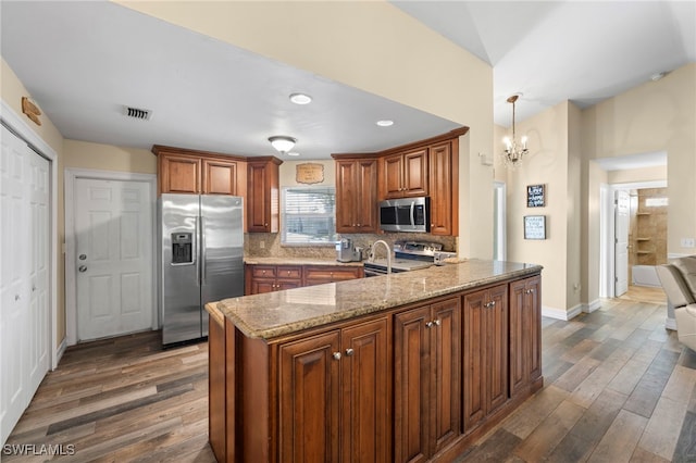 4560 Key Largo Ln, Bonita Springs, FL 34134 - kitchen with appliances with stainless steel finishes, dark wood finished floors, light stone counters, a peninsula, and recessed lighting