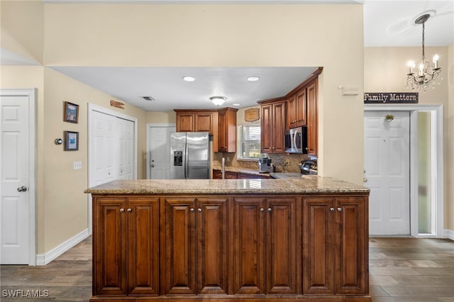 4560 Key Largo Ln, Bonita Springs, FL 34134 - kitchen featuring stainless steel appliances, dark wood-style floors, baseboards, a chandelier, and a peninsula