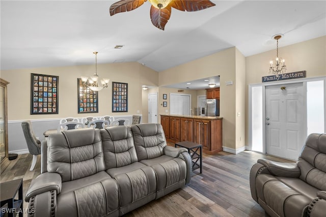 4560 Key Largo Ln, Bonita Springs, FL 34134 - living room featuring a chandelier, vaulted ceiling, wood finished floors, a ceiling fan, and baseboards