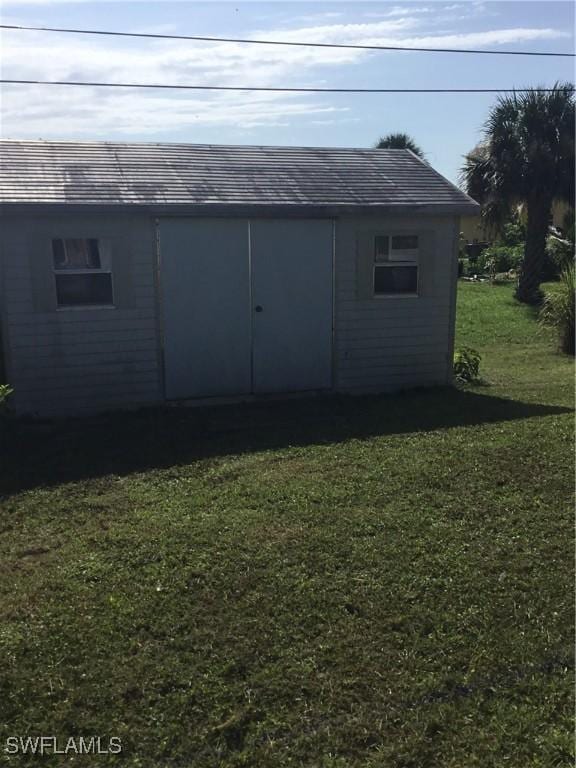 view of outdoor structure featuring a lawn