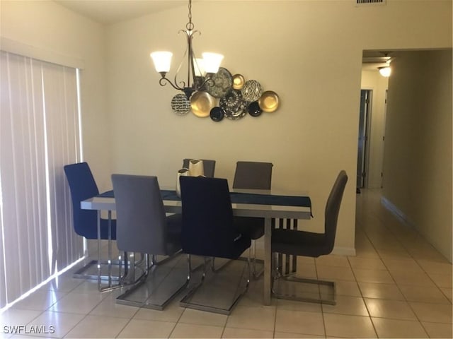 tiled dining space featuring a chandelier