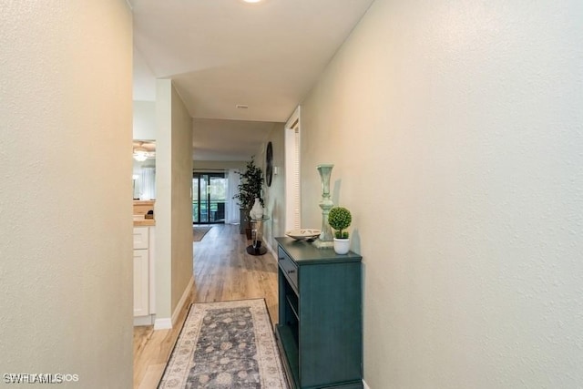 corridor with light hardwood / wood-style flooring