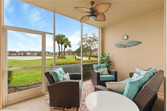 sunroom featuring a water view, ceiling fan, and a healthy amount of sunlight