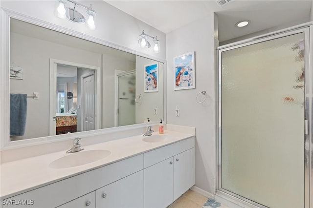 bathroom with an enclosed shower, vanity, and tile patterned floors