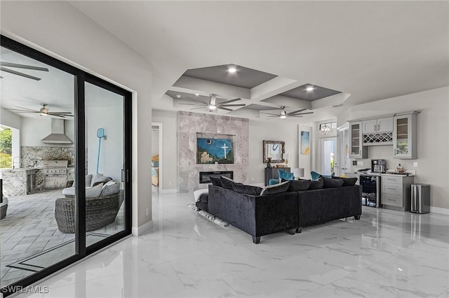 living room featuring a high end fireplace, coffered ceiling, beam ceiling, wine cooler, and bar