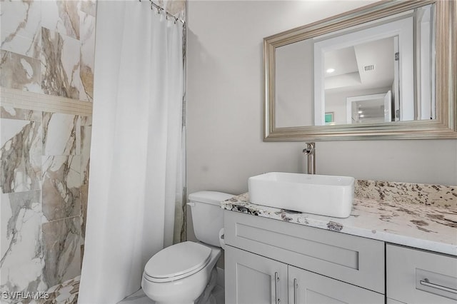 bathroom featuring vanity, toilet, and curtained shower