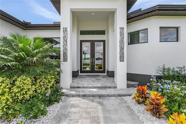 entrance to property featuring french doors and stucco siding