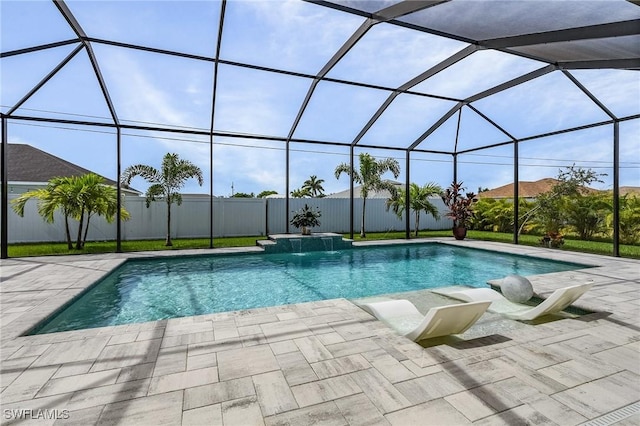 view of pool with pool water feature, glass enclosure, and a patio area