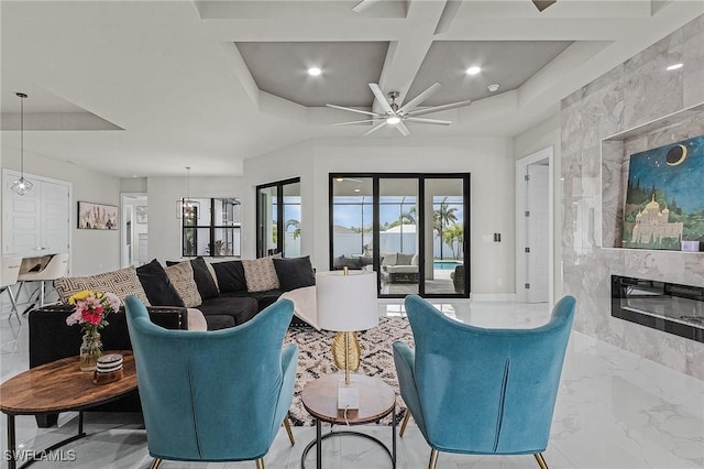 living room featuring ceiling fan, a high end fireplace, and coffered ceiling