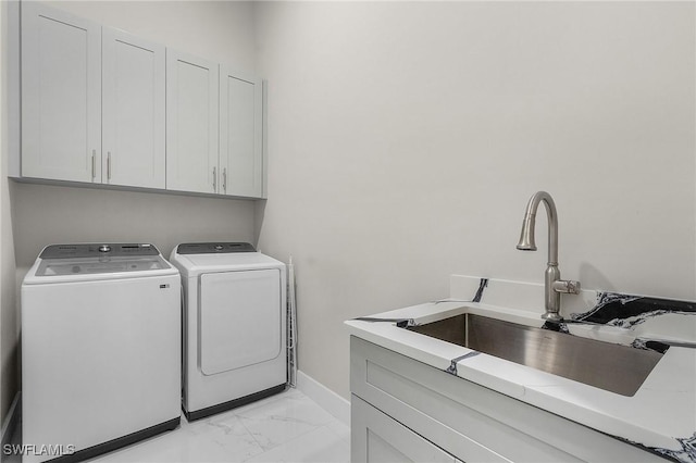 laundry room featuring cabinets, sink, and washing machine and clothes dryer