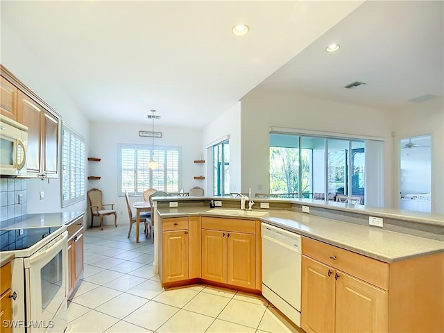 kitchen featuring pendant lighting, sink, light tile patterned floors, kitchen peninsula, and white appliances