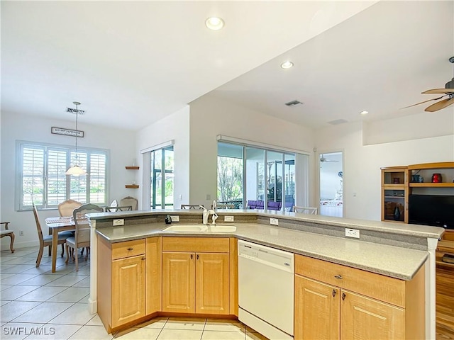 kitchen featuring sink, light tile patterned floors, plenty of natural light, white dishwasher, and decorative light fixtures