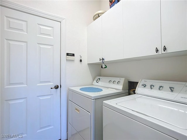 washroom with cabinets and washer and dryer