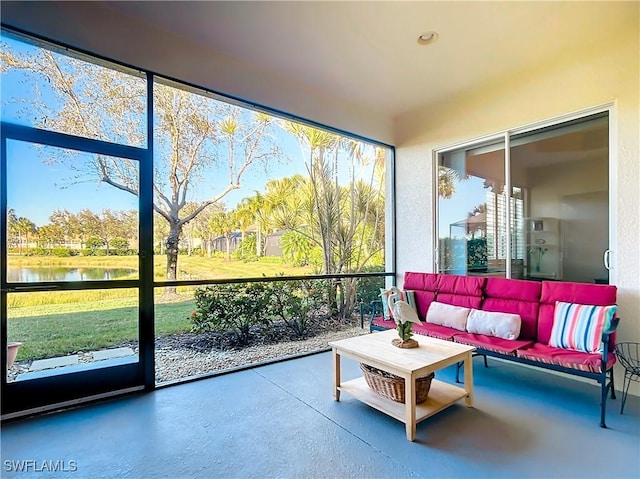 sunroom featuring a water view