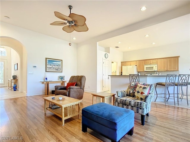 living room featuring light hardwood / wood-style flooring and ceiling fan