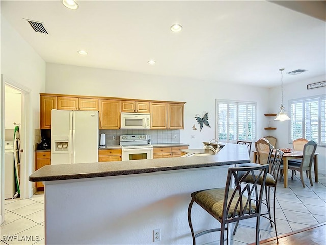 kitchen featuring sink, white appliances, light tile patterned floors, hanging light fixtures, and backsplash