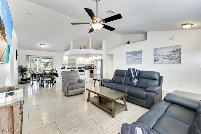 living room with ceiling fan, light tile patterned flooring, and vaulted ceiling