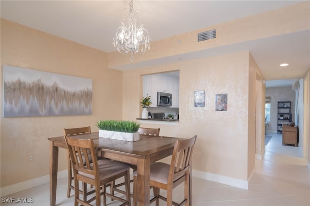 tiled dining area featuring a chandelier