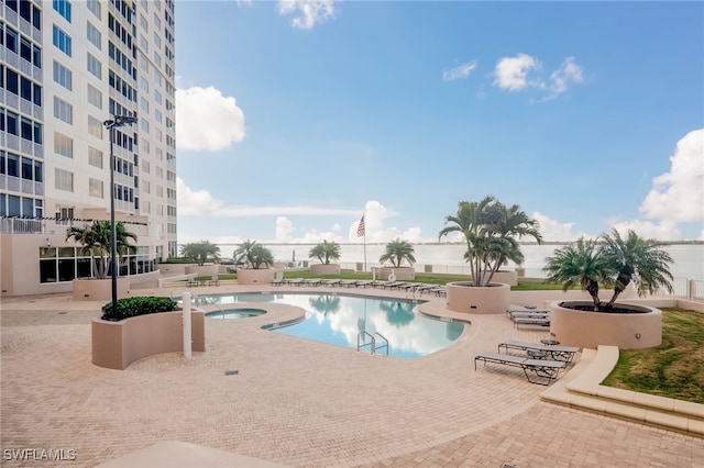 view of swimming pool featuring a patio and a hot tub