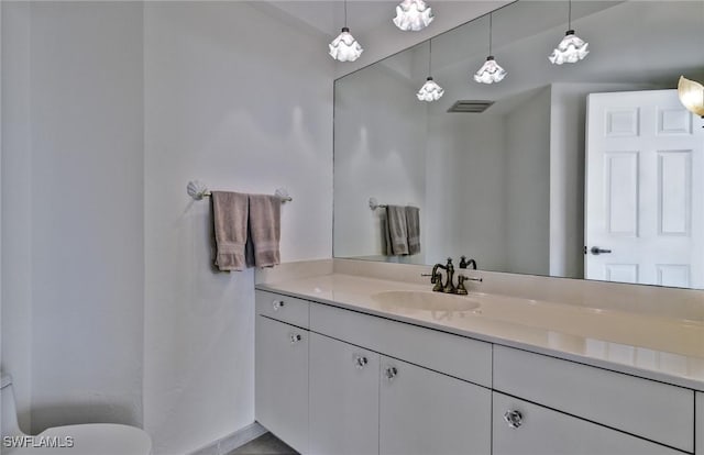 bathroom with toilet, vanity, and tile patterned floors