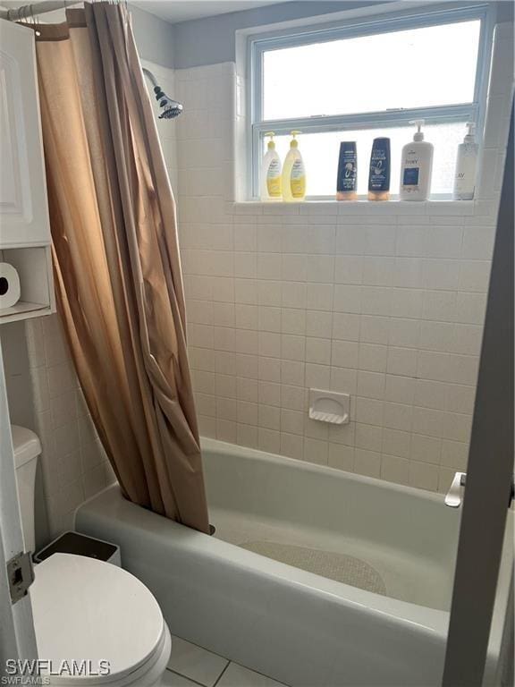 bathroom featuring toilet, tile patterned floors, and shower / bath combo