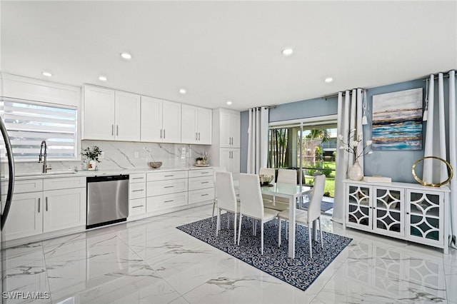 kitchen featuring dishwasher, tasteful backsplash, white cabinetry, and a healthy amount of sunlight