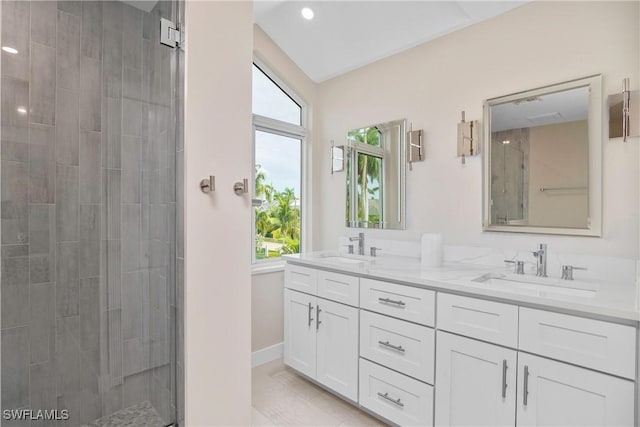 bathroom with tile patterned floors, vanity, and tiled shower