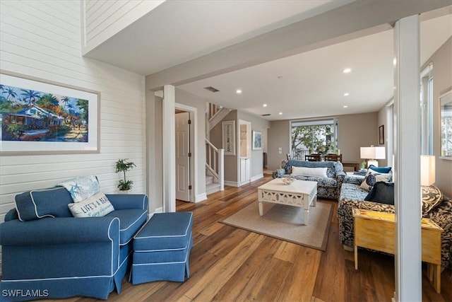 living room with wood-type flooring and wooden walls