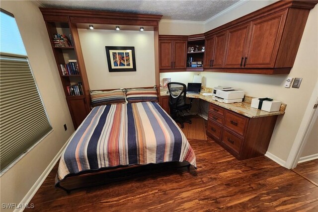 bedroom with a textured ceiling, built in desk, dark hardwood / wood-style flooring, and ornamental molding