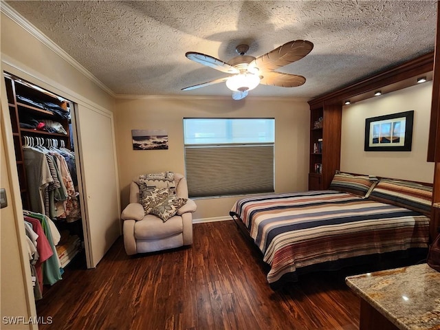 bedroom featuring ornamental molding, a textured ceiling, ceiling fan, dark wood-type flooring, and a closet