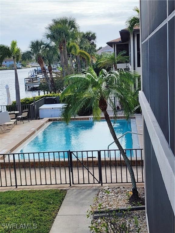 view of swimming pool with a water view and a patio