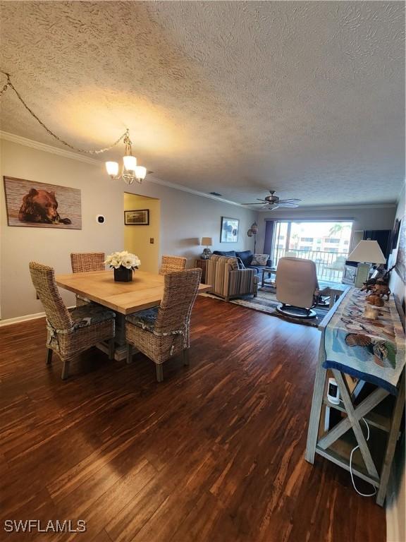 dining space featuring hardwood / wood-style floors, a textured ceiling, and ornamental molding