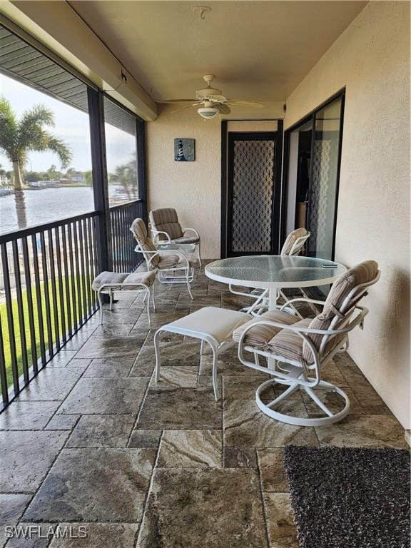 exterior space with ceiling fan and a water view