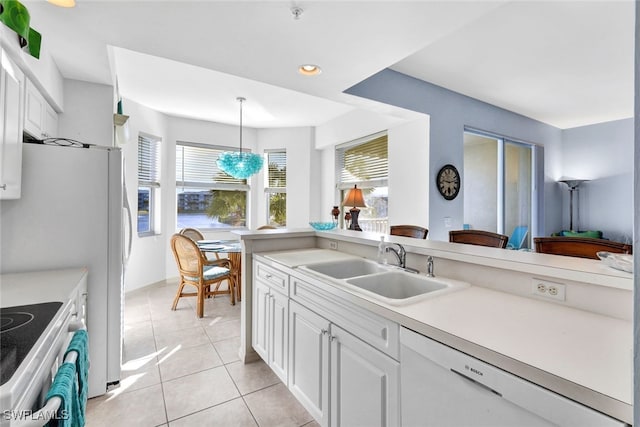 kitchen with dishwasher, sink, light tile patterned floors, decorative light fixtures, and white cabinets